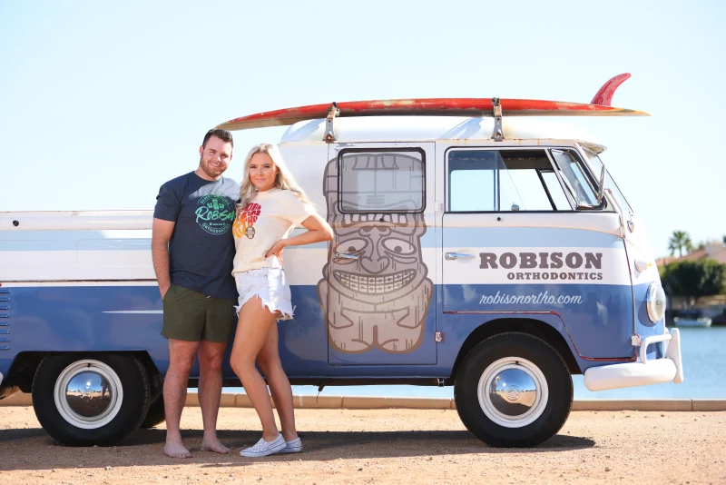 a male and female posing on the side of a van
