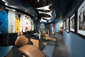 Modern orthodontic office: Dental treatment chairs, decorative surfboards on wall, and contemporary ceiling fixtures.